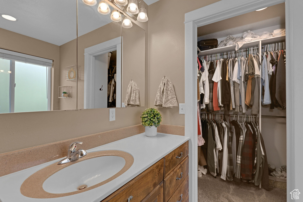 Bathroom featuring vanity and a spacious closet