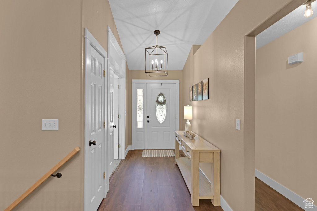 Foyer with dark wood-style flooring and a chandelier