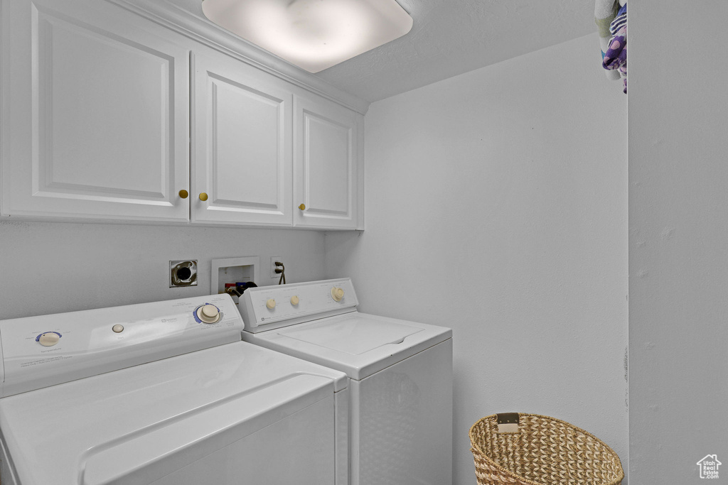 Laundry area featuring cabinet space and washer and clothes dryer