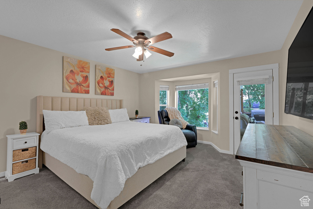 Bedroom featuring dark carpet, access to outside, and ceiling fan
