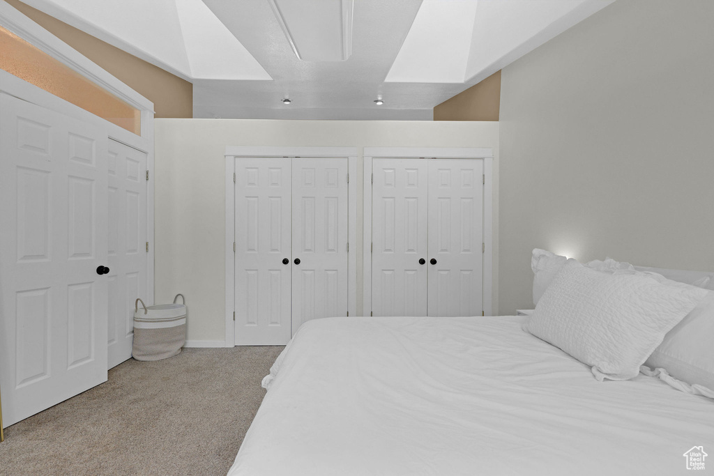 Bedroom featuring carpet floors and two closets