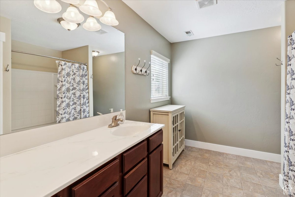Full bathroom featuring vanity, a chandelier, and a shower with shower curtain