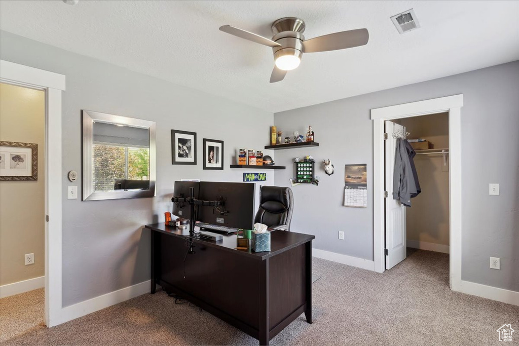 Office area featuring carpet floors and ceiling fan