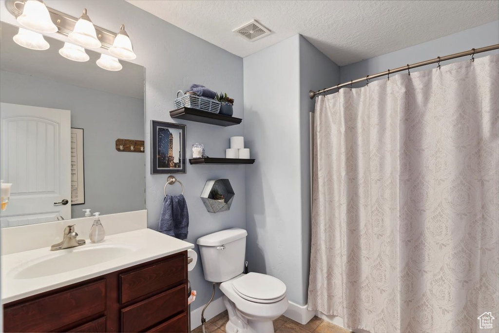 Bathroom with vanity, tile patterned floors, a textured ceiling, and a shower with curtain