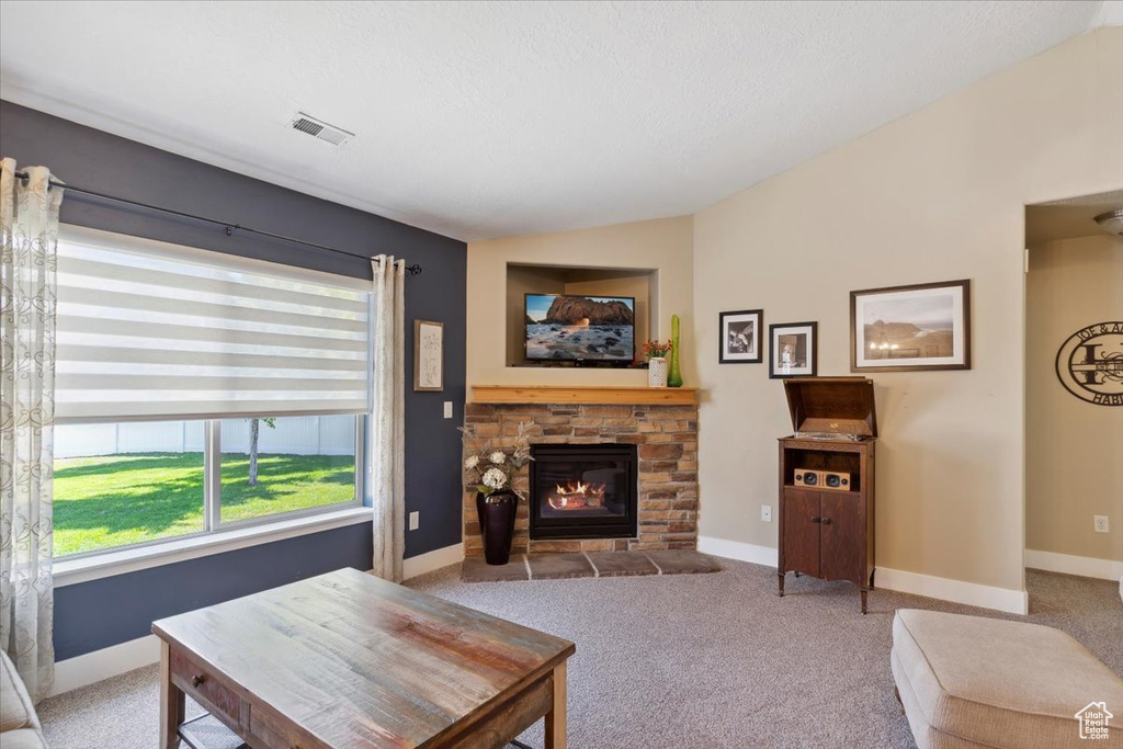 Living area with lofted ceiling, carpet floors, and a fireplace