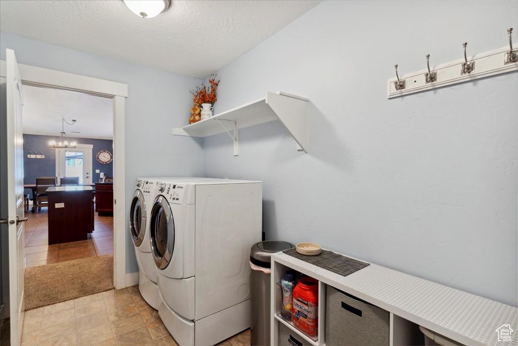 Laundry room with washing machine and dryer and a chandelier