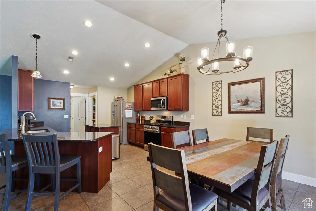 Dining area featuring a chandelier, light tile patterned floors, lofted ceiling, and recessed lighting