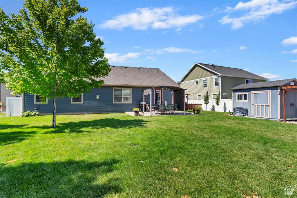 Rear view of property featuring a storage shed and a patio