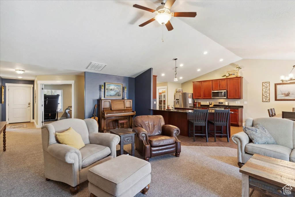 Living area with light carpet, ceiling fan, recessed lighting, lofted ceiling, and a chandelier