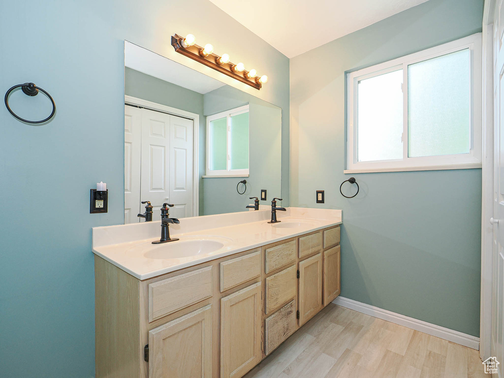 Bathroom with double vanity and wood finished floors