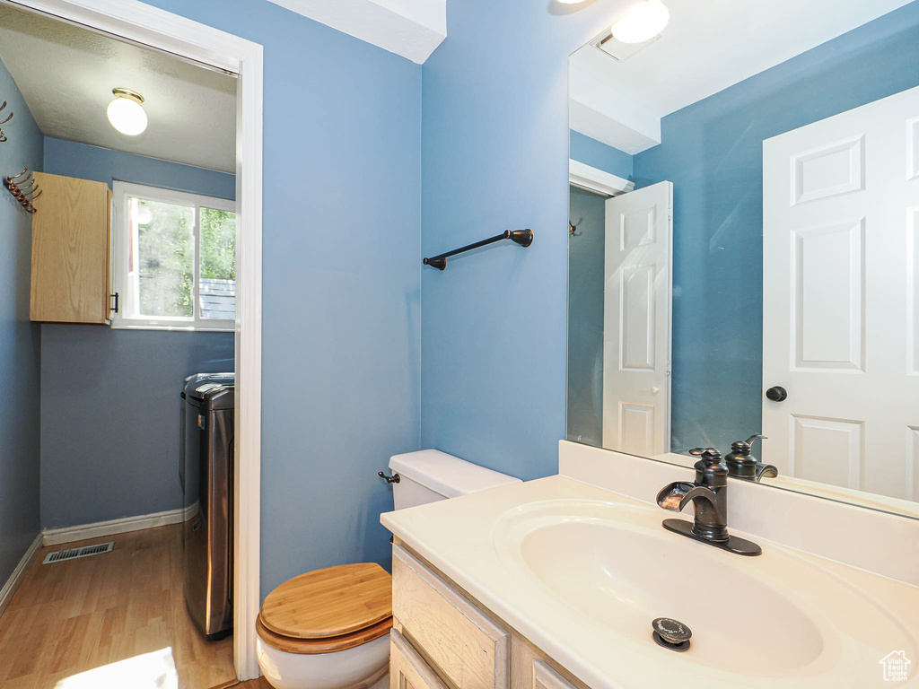 Bathroom with wood finished floors, vanity, and separate washer and dryer