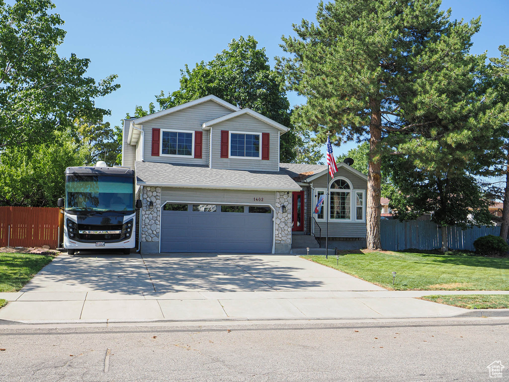 Traditional-style home with an attached garage, driveway, and stone siding