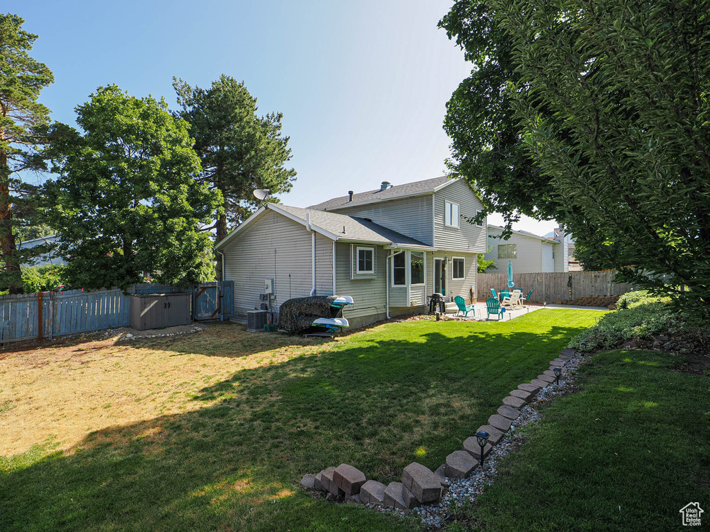 Back of property with a patio area, a gate, and a fenced backyard