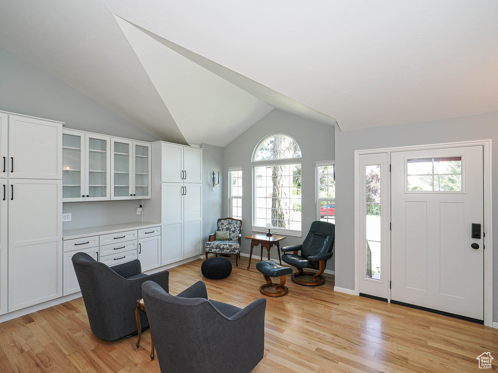 Living room with lofted ceiling and light wood-style flooring