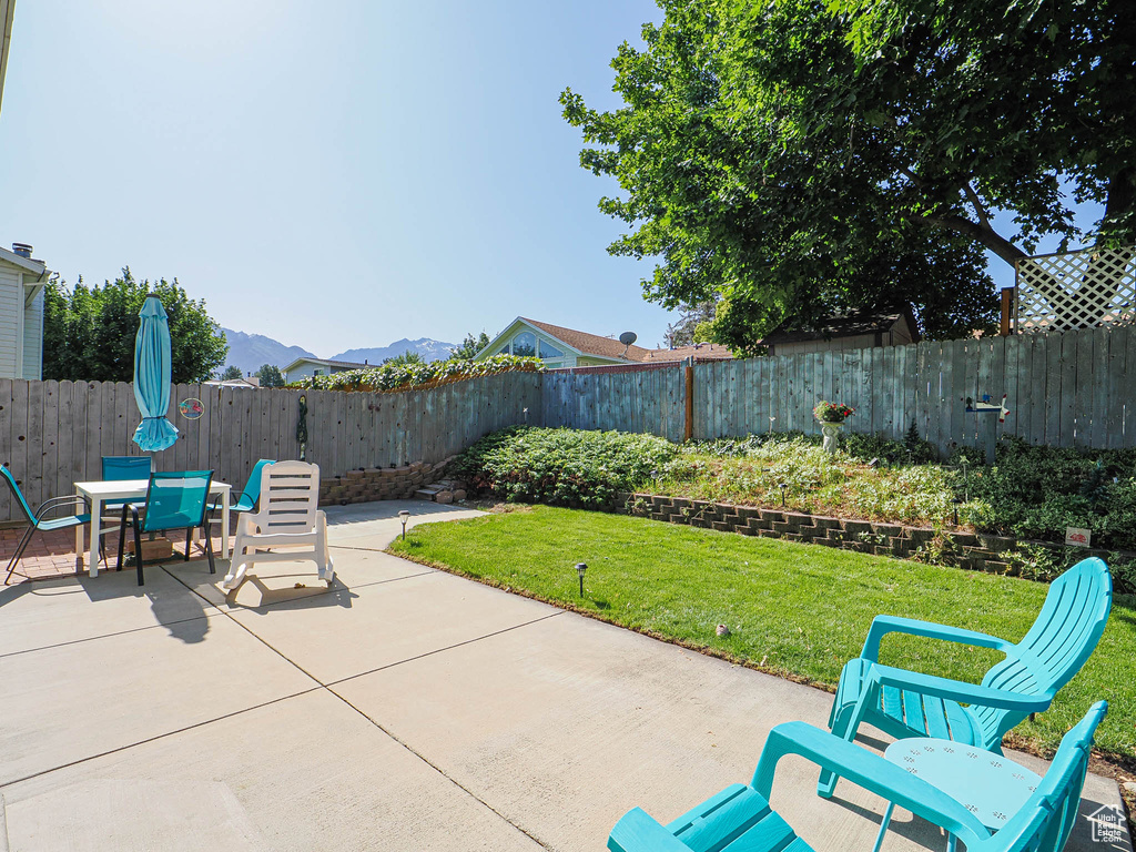 Fenced backyard featuring a patio area, a mountain view, and outdoor dining space