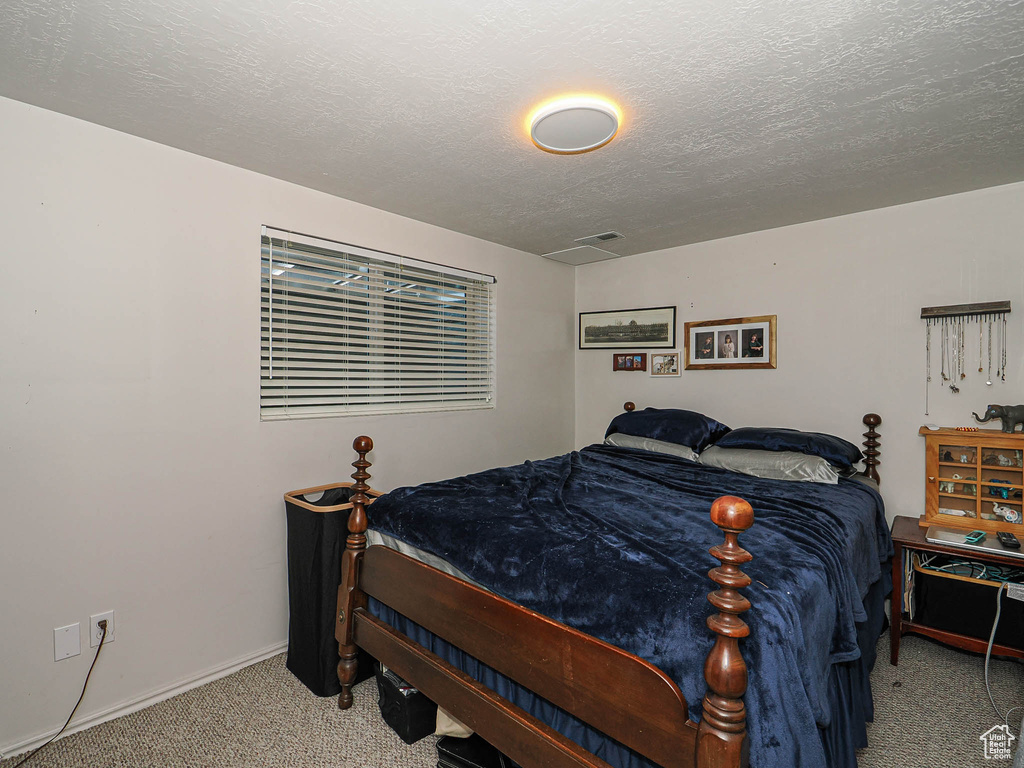 Bedroom featuring carpet flooring and a textured ceiling