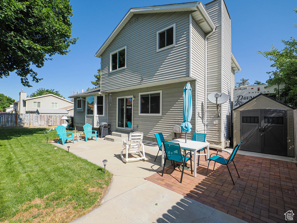 Back of property with a patio, entry steps, and a shed