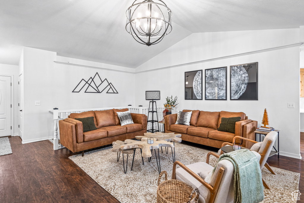 Living area with a chandelier, dark wood finished floors, and vaulted ceiling