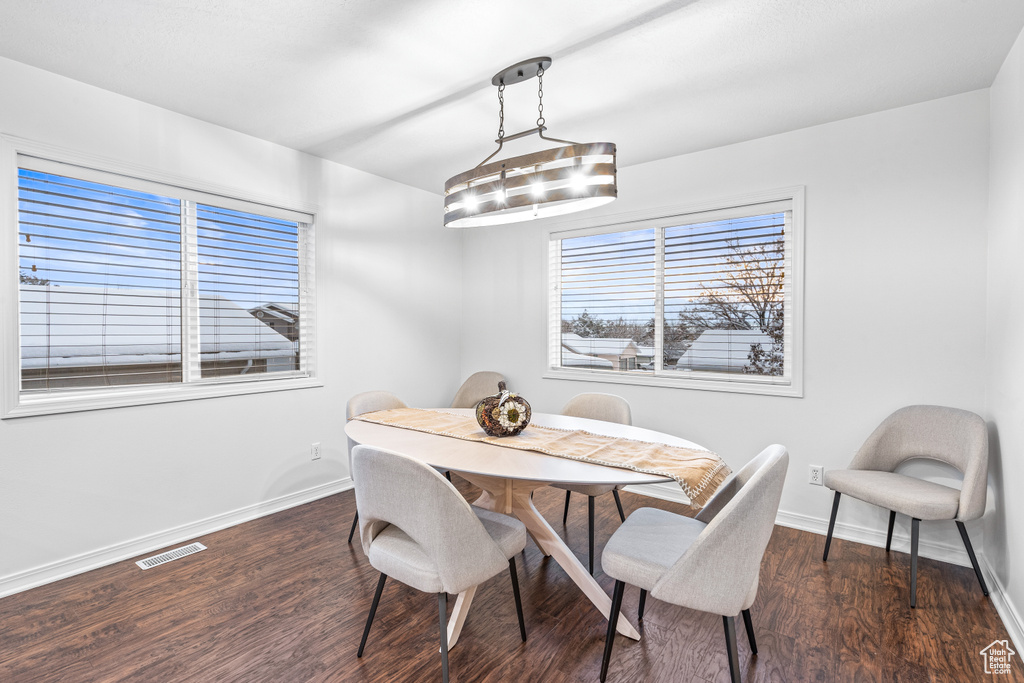 Dining area with baseboards and dark wood-style flooring