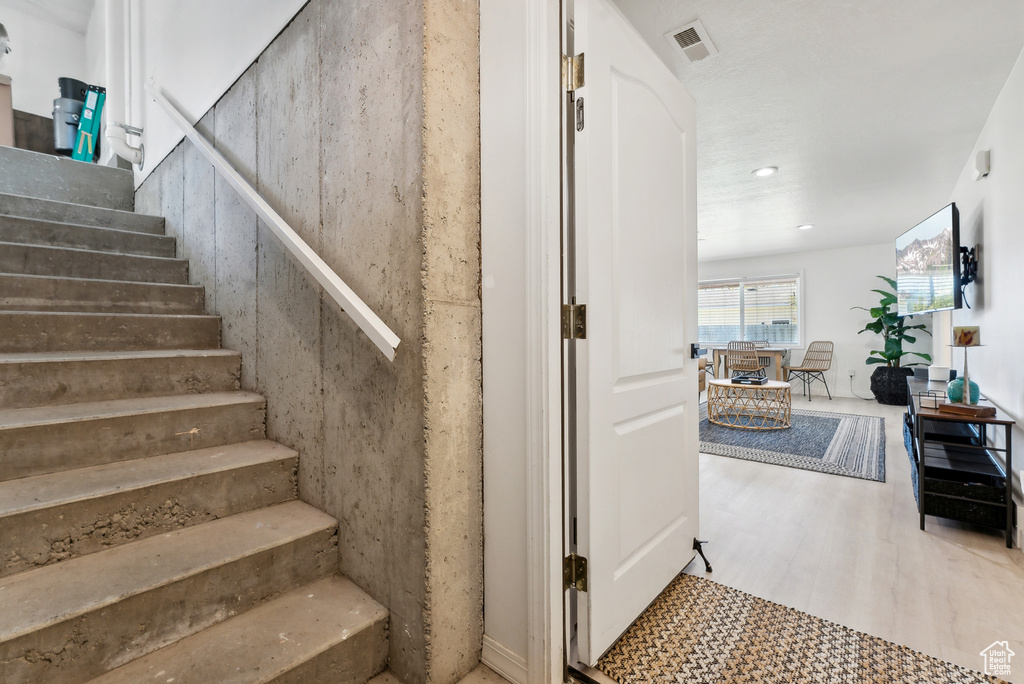 Stairway featuring wood finished floors