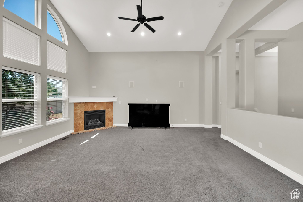 Unfurnished living room with a tile fireplace, carpet flooring, a ceiling fan, high vaulted ceiling, and recessed lighting