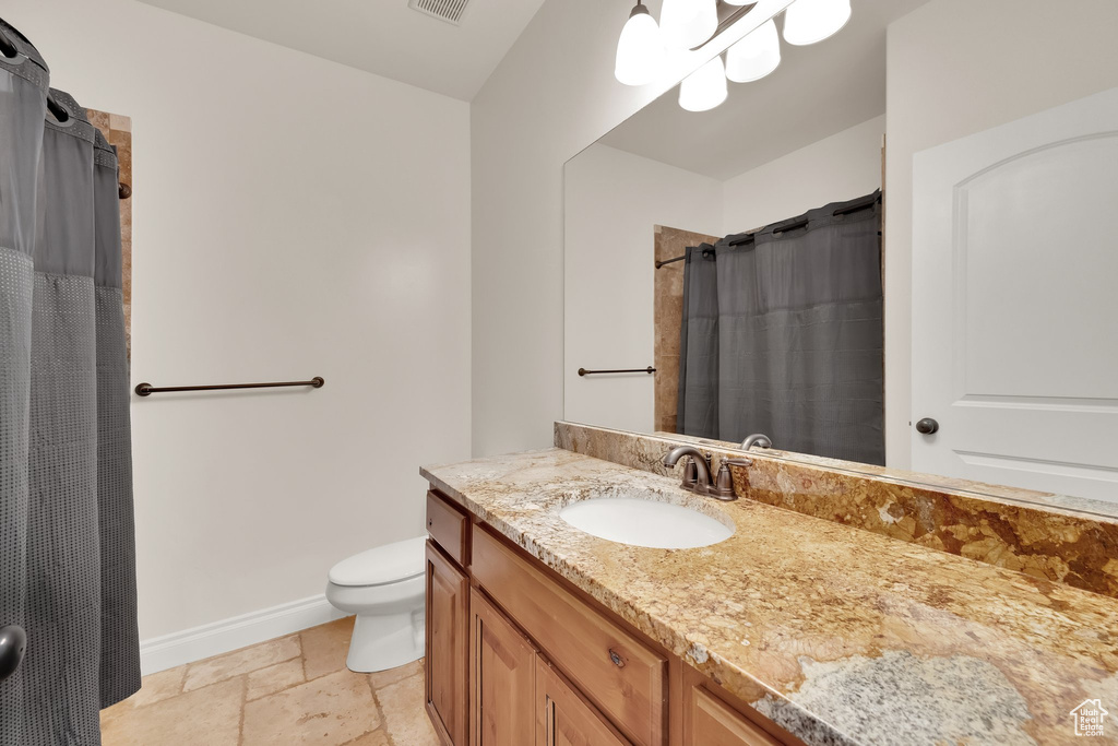 Bathroom featuring vanity, stone tile floors, and a shower with curtain