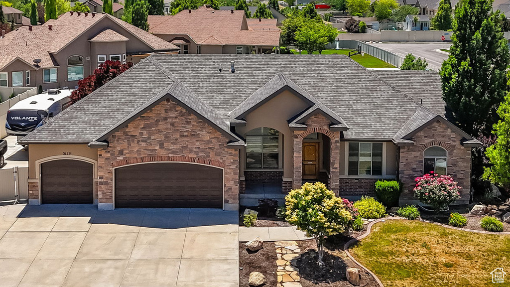 View of front of house with concrete driveway, an attached garage, and brick siding