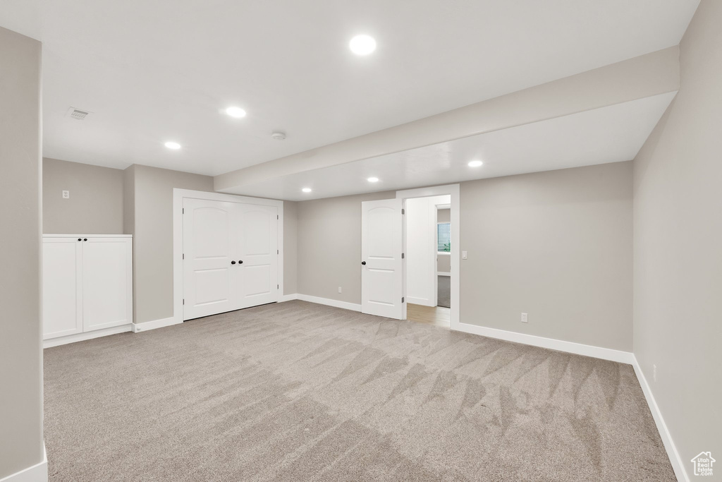 Finished basement with recessed lighting and carpet