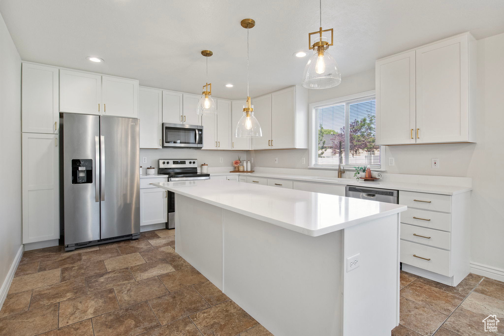 Kitchen featuring appliances with stainless steel finishes, dark stone finish floors, recessed lighting, and white cabinets