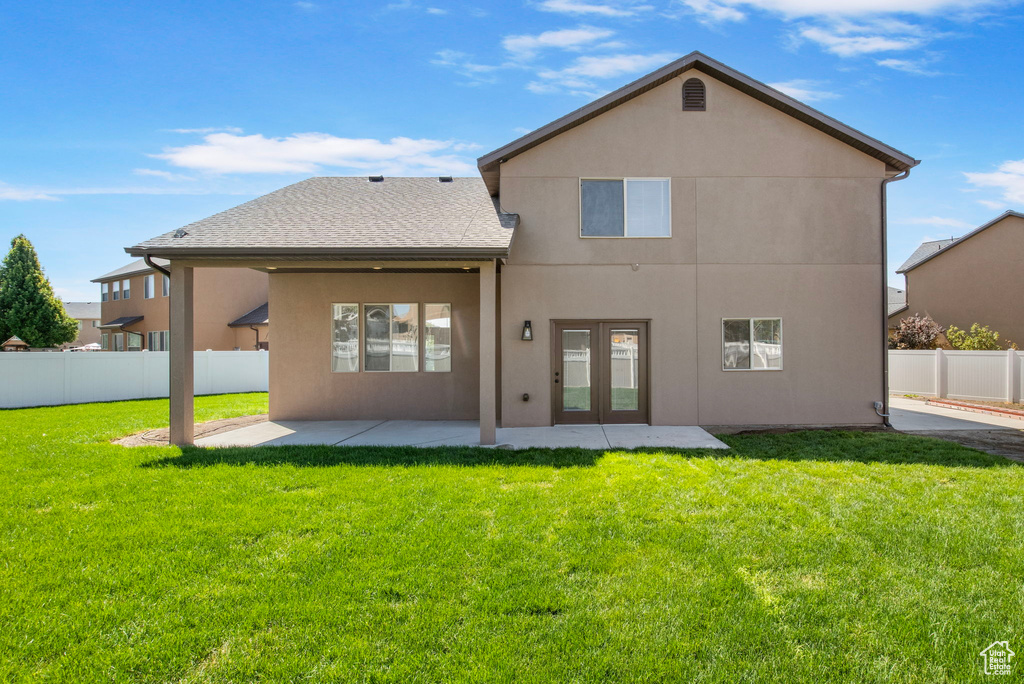 Back of property featuring a patio, stucco siding, a fenced backyard, and french doors