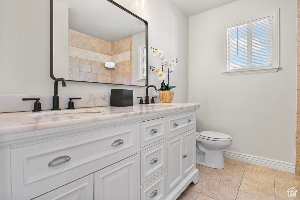Bathroom with double vanity, tile patterned flooring, and a shower