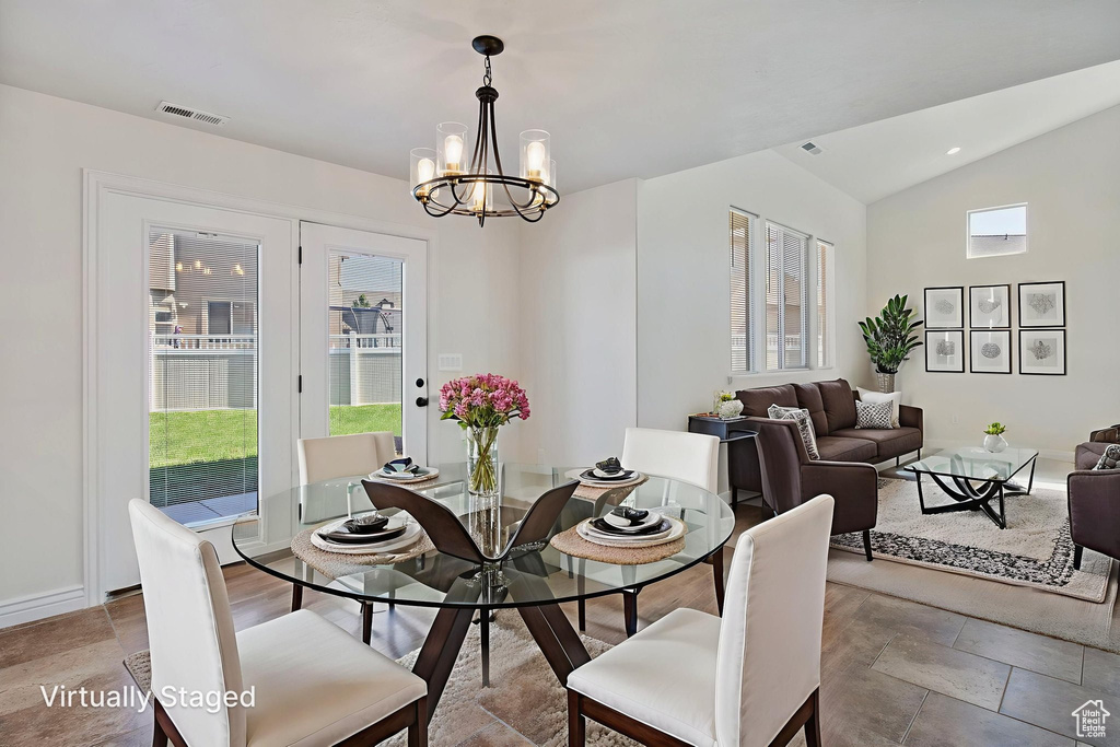 Dining area with a chandelier and lofted ceiling