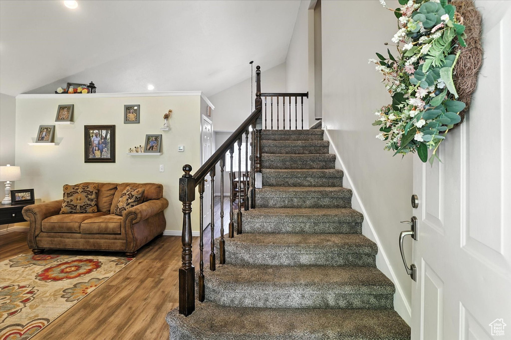 Stairs featuring lofted ceiling, wood finished floors, and recessed lighting
