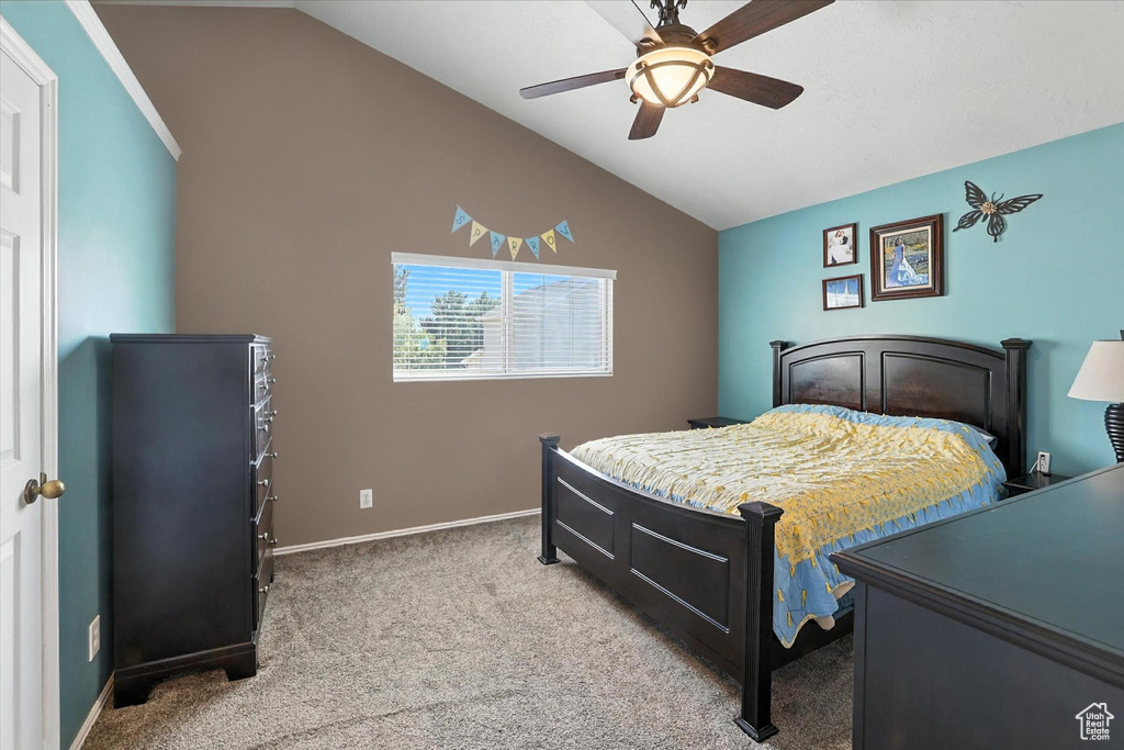 Carpeted bedroom featuring vaulted ceiling and ceiling fan