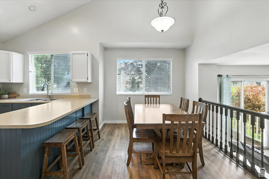 Dining space featuring high vaulted ceiling, light wood finished floors, and plenty of natural light