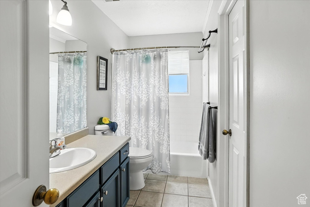 Bathroom with vanity, shower / bath combo with shower curtain, and tile patterned floors