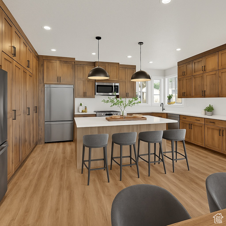 Kitchen with stainless steel appliances, a center island, brown cabinets, light countertops, and a kitchen breakfast bar