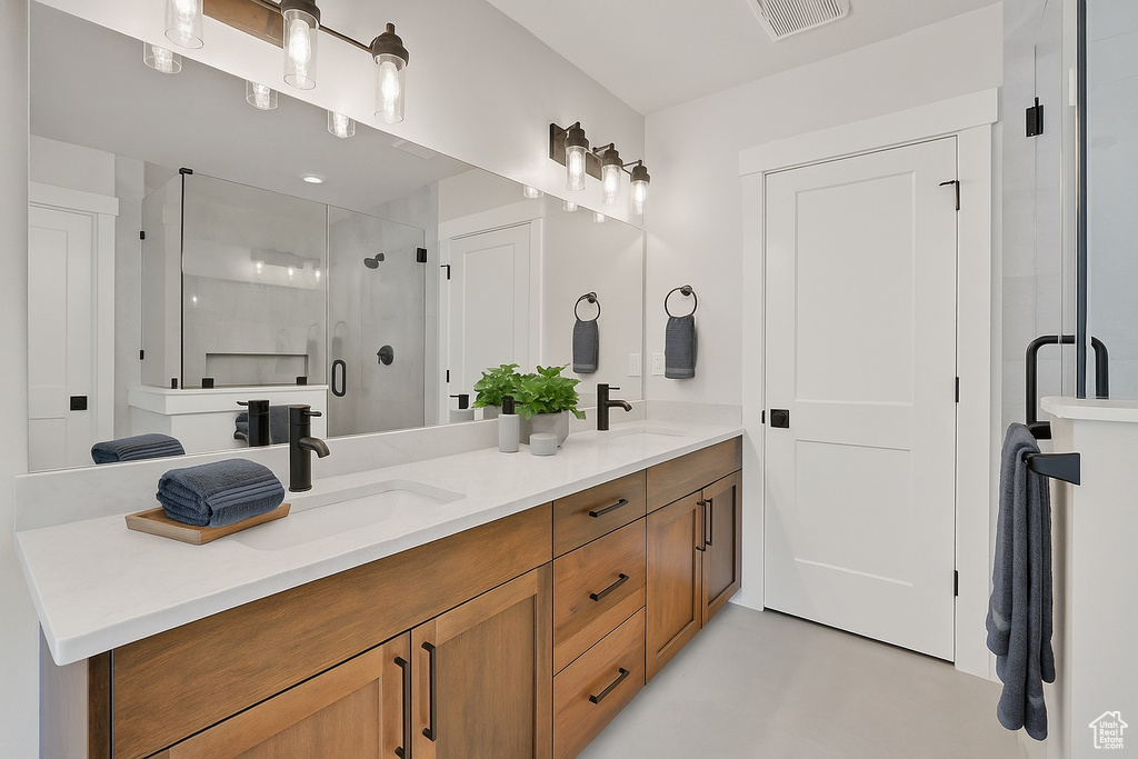 Bathroom featuring double vanity and a shower stall