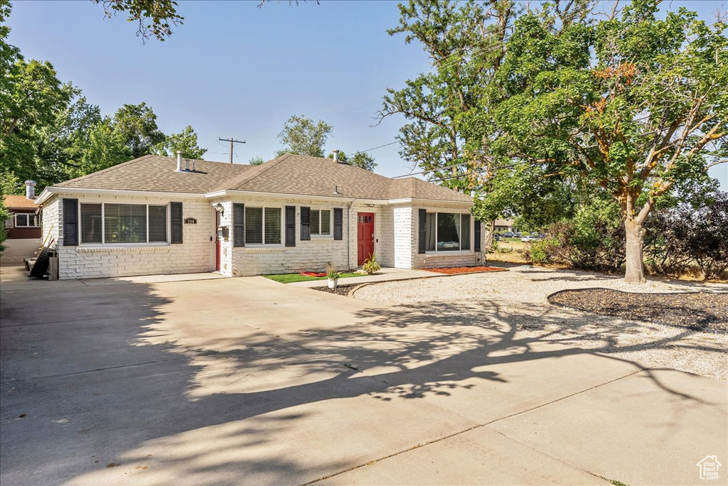 Single story home with concrete driveway and roof with shingles