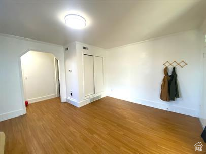 Bonus room with arched walkways and wood finished floors