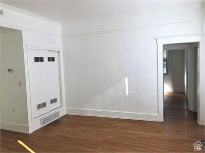 Spare room featuring baseboards and wood finished floors