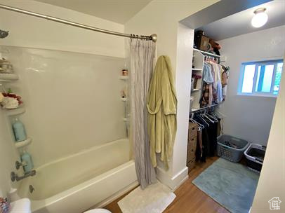 Full bathroom with shower / bathtub combination with curtain and wood finished floors