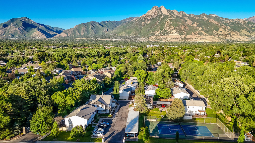 Aerial view of property and surrounding area with mountains and nearby suburban area