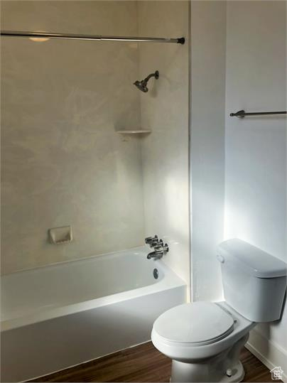Bathroom with wood finished floors and washtub / shower combination
