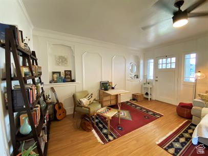 Living room with ornamental molding, wood finished floors, and ceiling fan