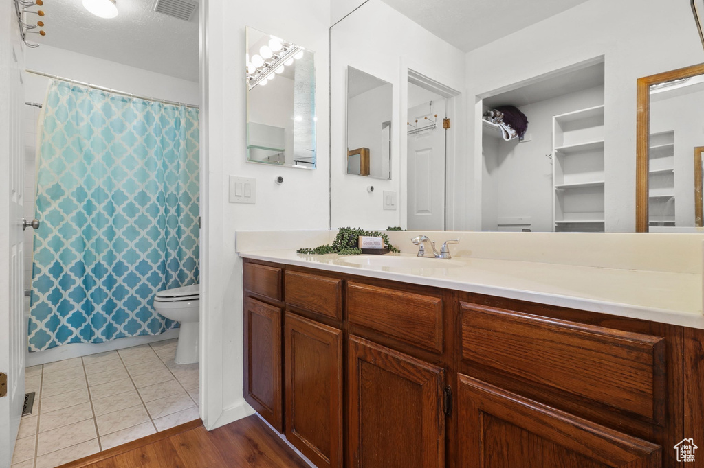 Bathroom with vanity, a shower with shower curtain, and tile patterned flooring