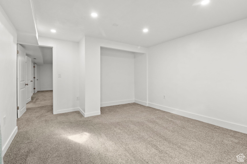 Basement with recessed lighting and light colored carpet