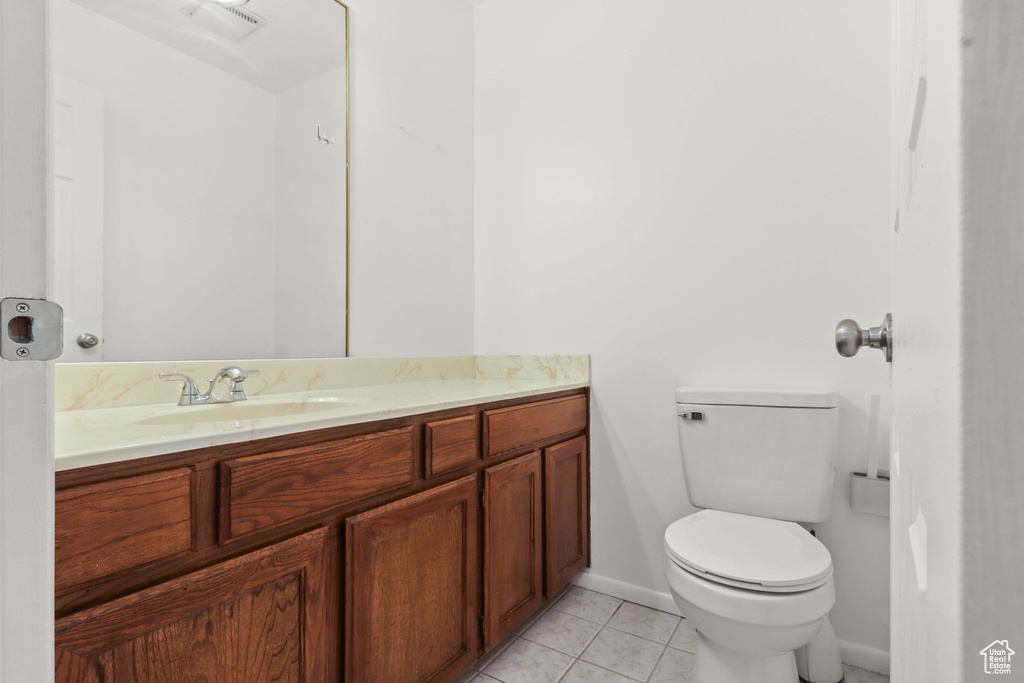 Half bath with vanity and tile patterned floors