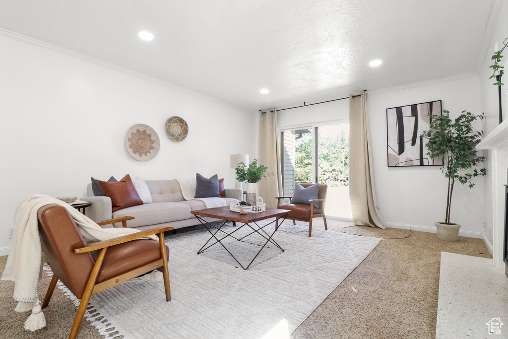 Living room featuring recessed lighting, crown molding, light colored carpet, and a fireplace with flush hearth