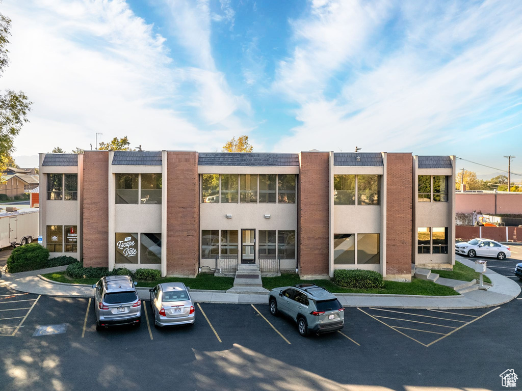 View of building exterior featuring uncovered parking